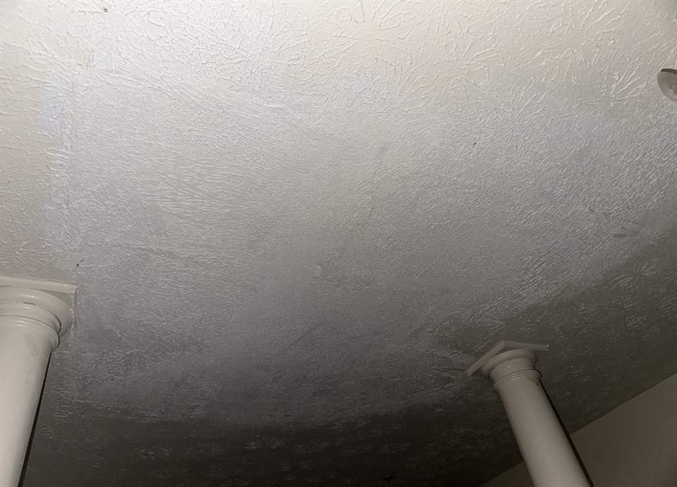 The same ceiling patched, retextured and repainted with no visible seam