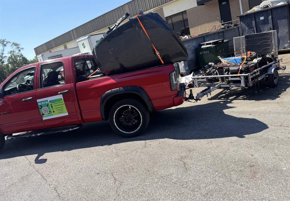 Pickup truck and trailer loaded with bulk items at a disposal site