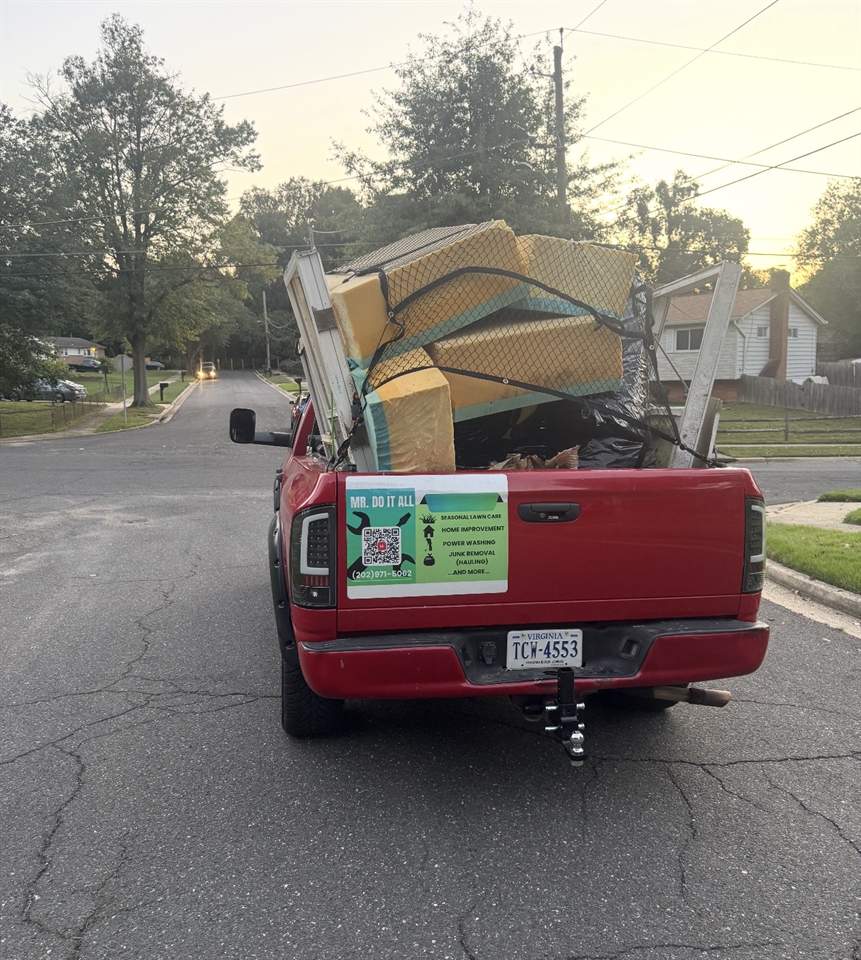 Pickup truck loaded with mattresses and debris at dusk