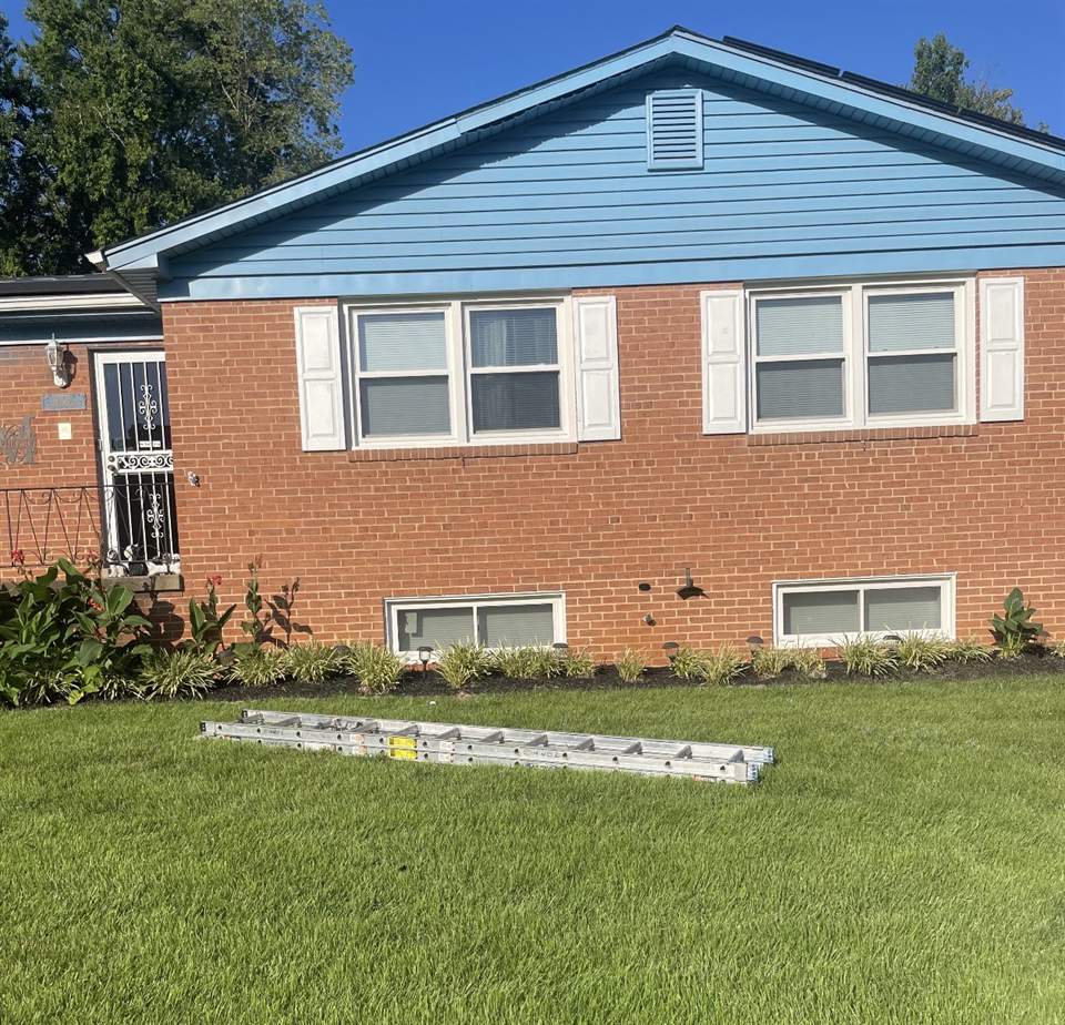 Brick house with freshly mulched planting beds and a cut lawn